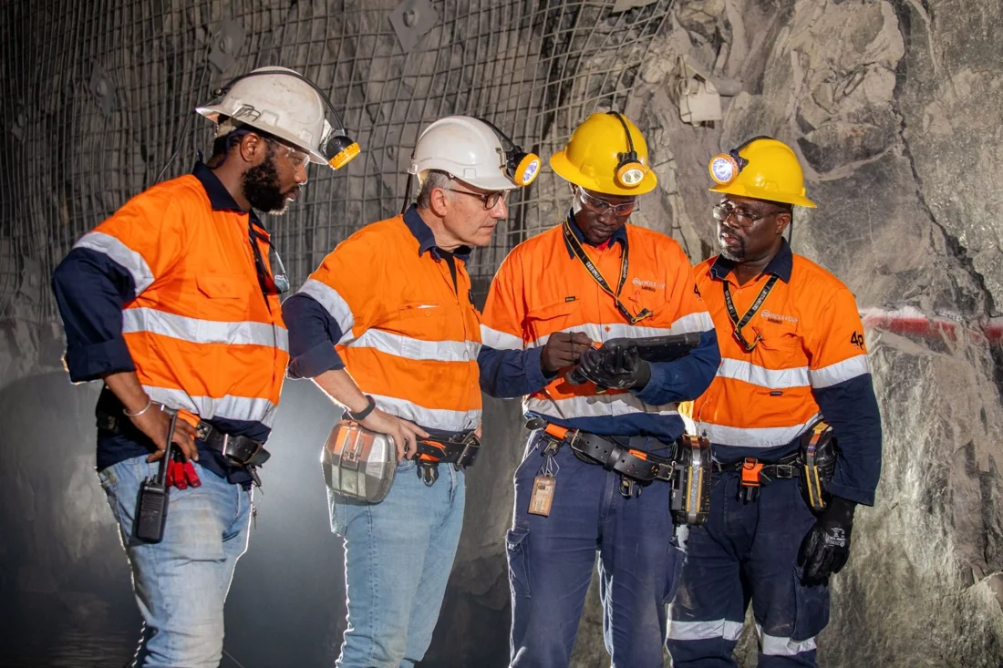 Underground mining team reviewing technical information